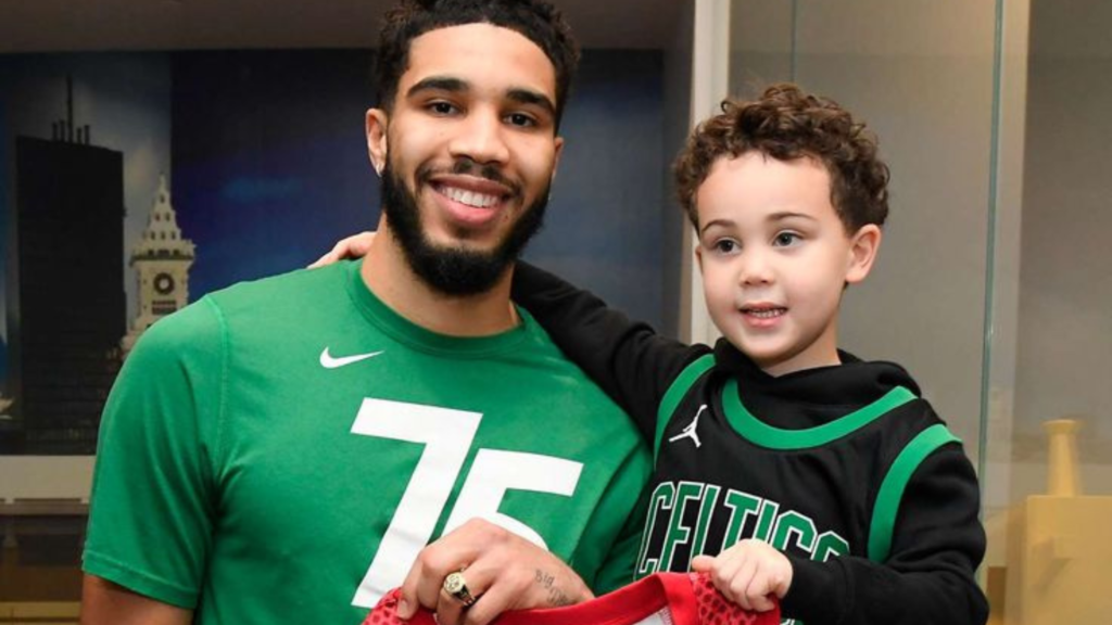 Jayson Tatum and his son holding a shirt