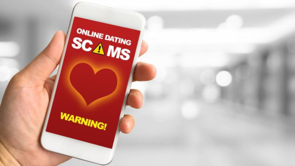 Holding a phone with "online dating scams warning" on the screen