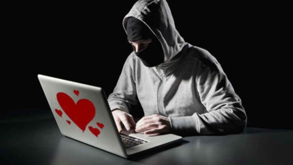 Romance scammer working on his laptop