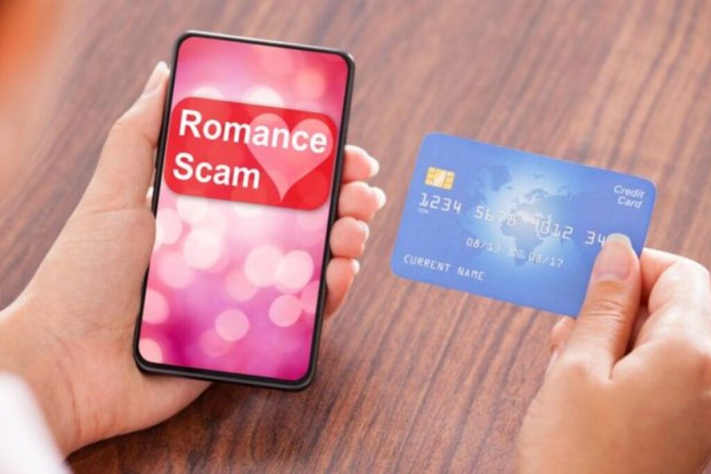 Holding a credit card and a phone with "Romance scam" on the screen