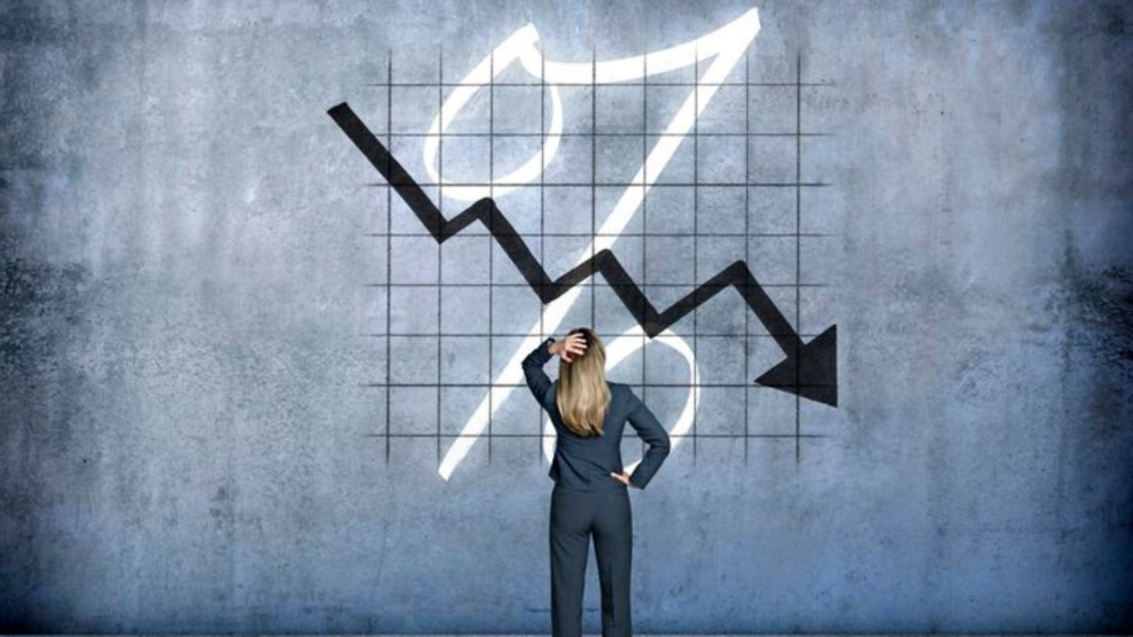 Woman looking at a graphical wall with a downward arrow and percentage