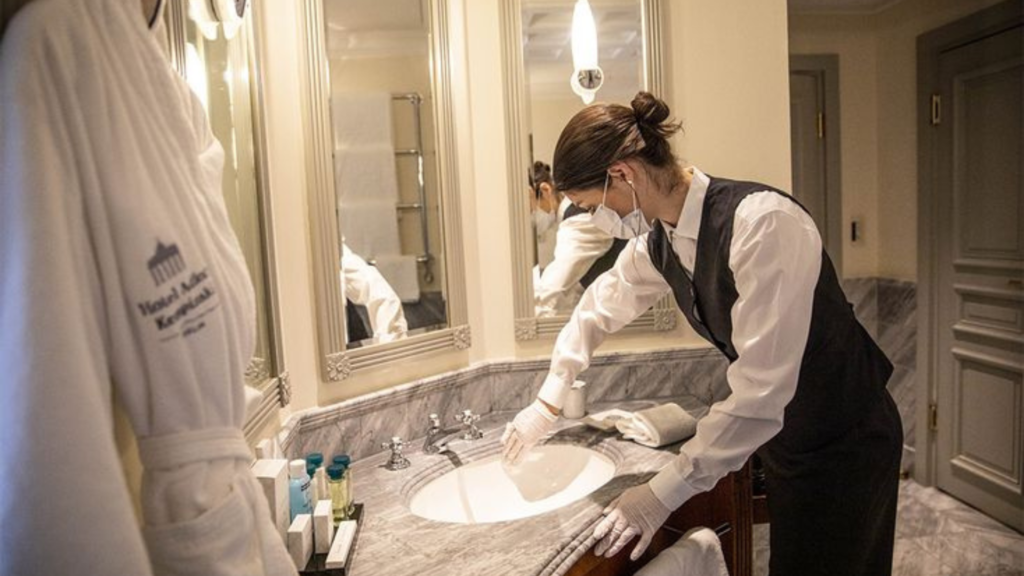 Woman cleaning a hotel bathroom