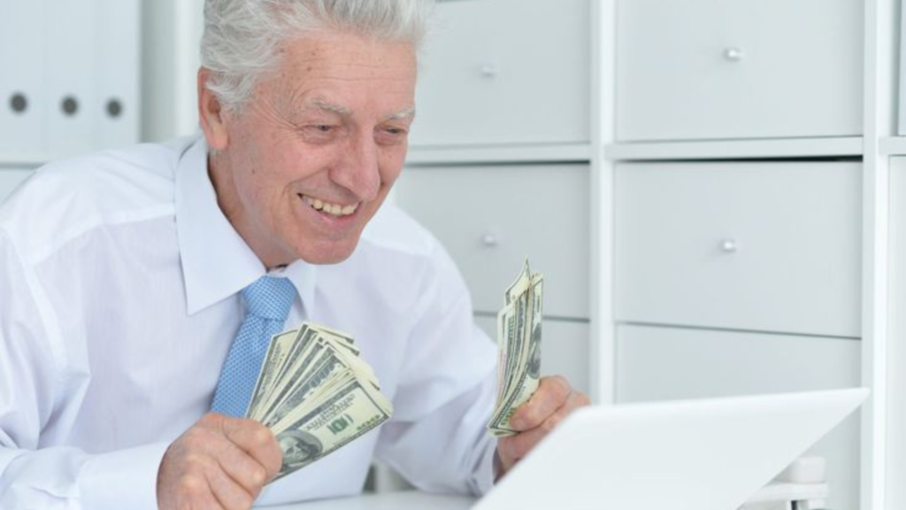 An elderly man holding some cash