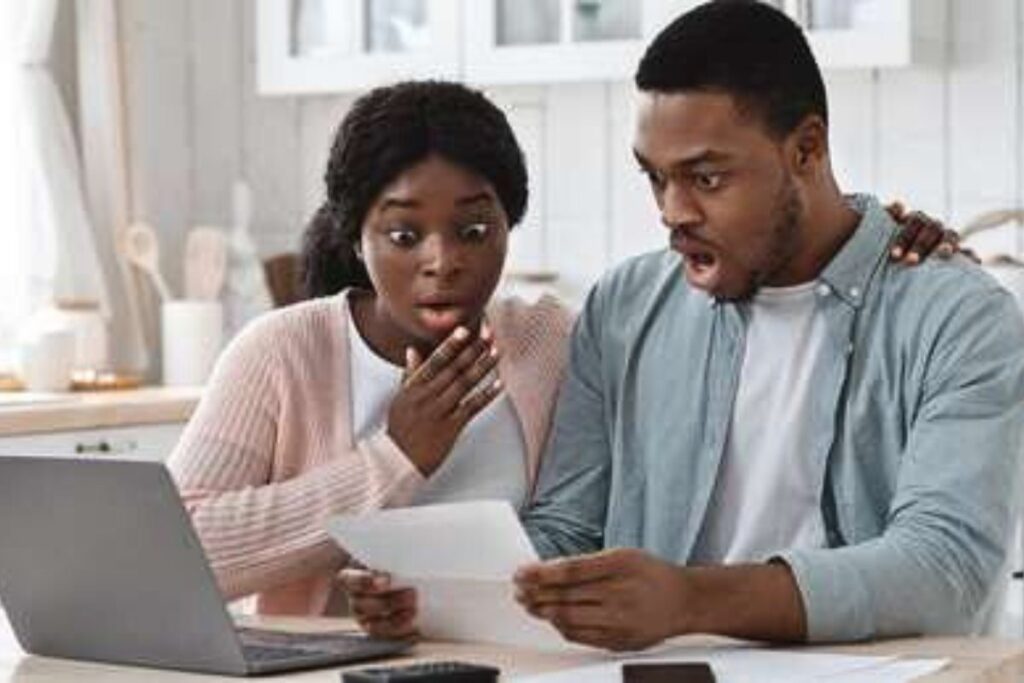 Couple reacting shocked to a document