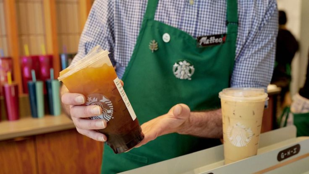 A barista holding a cup of coffee