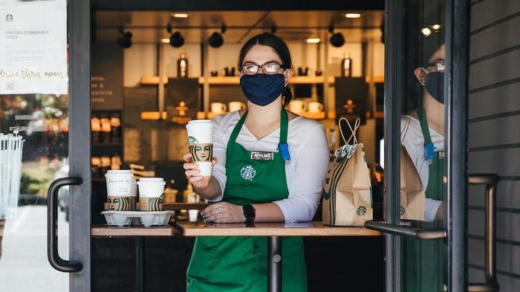 A barista serving coffee at Starbucks