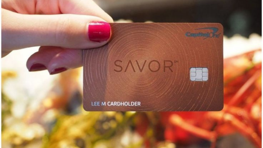 A woman holding a CapitalOne credit card