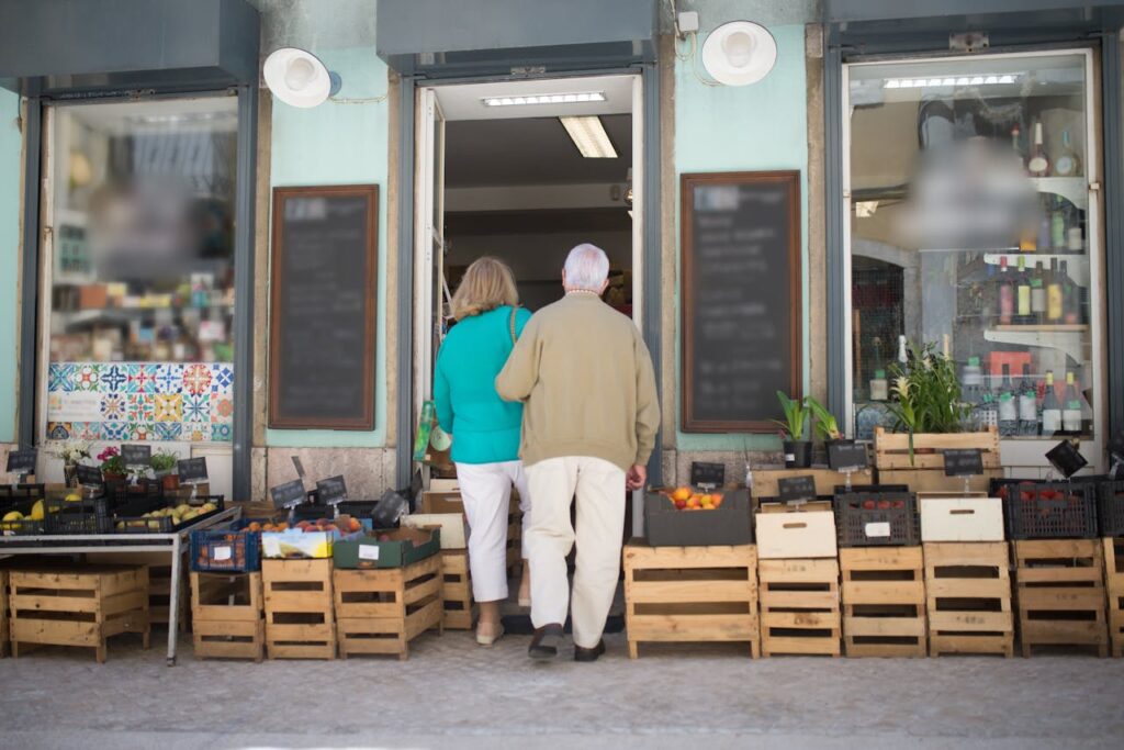 Back view of the elderly couple entering the store together