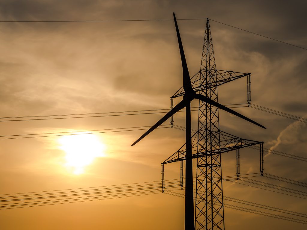 Wind turbine with a pylon in the background