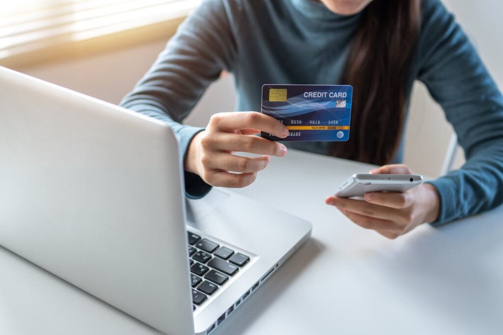 Woman Holding A Credit Card and cell phone