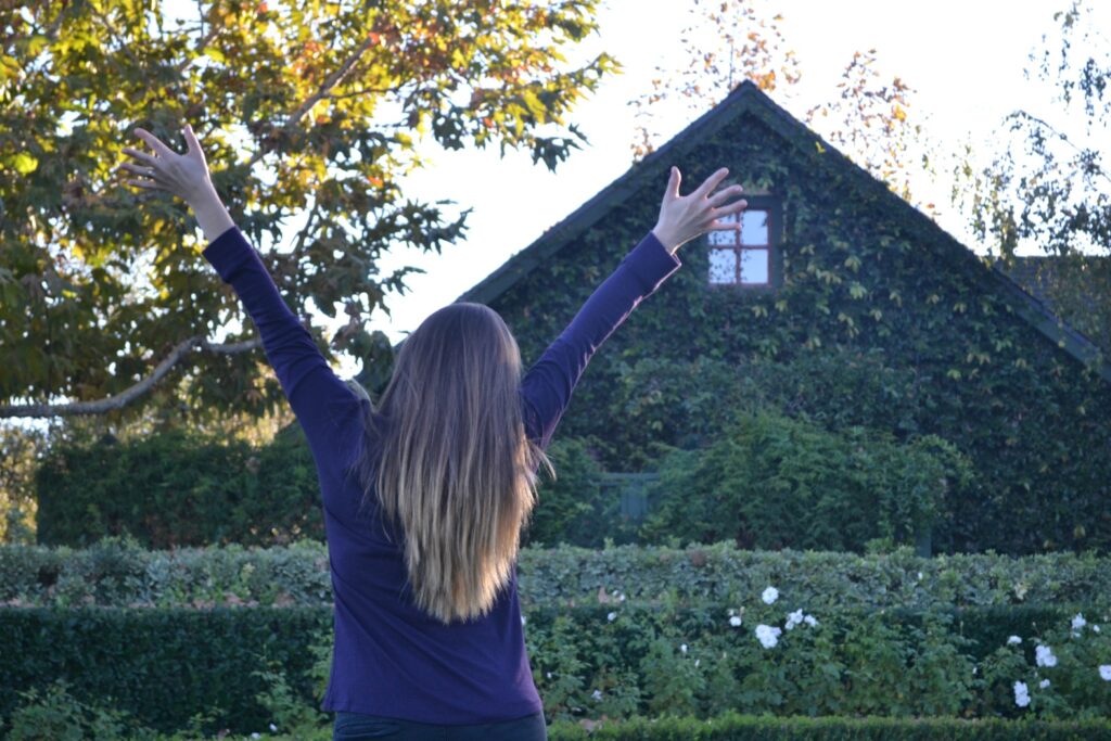 Elated woman standing outside a house