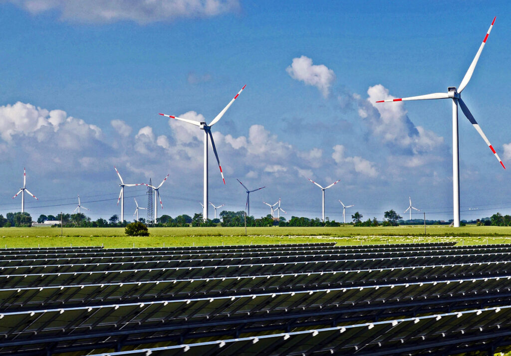 Solar panels, wind turbines, and an electricity pylon