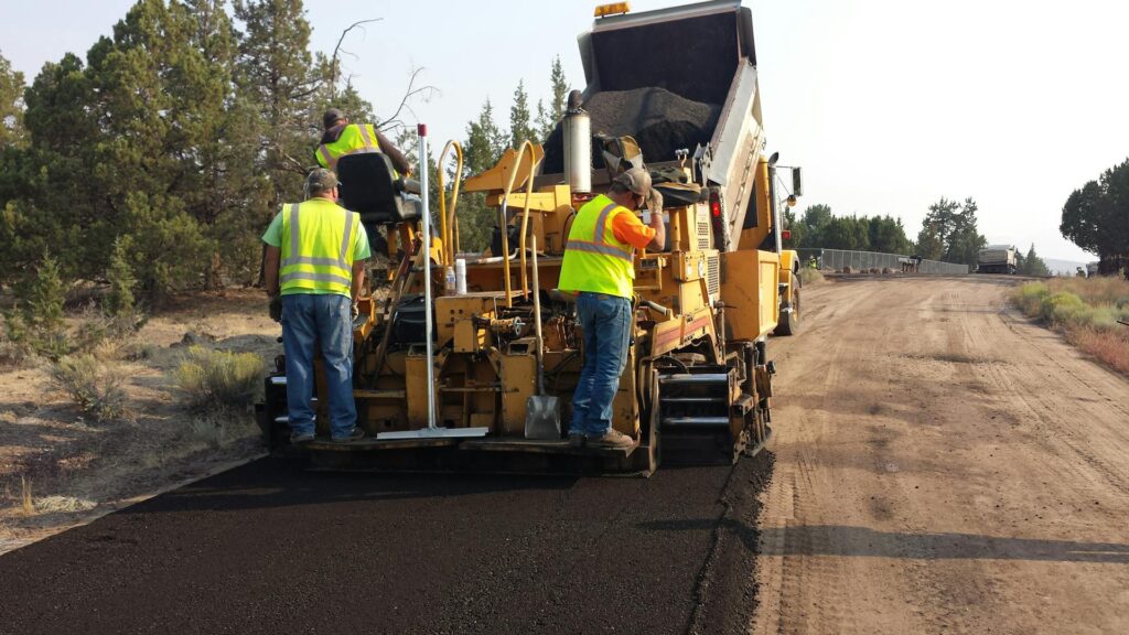 Men in High-Visibility Clothing on an Asphalt Paver