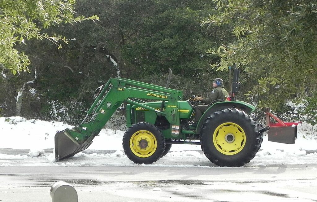 A John Deere 5215 tractor removing snow