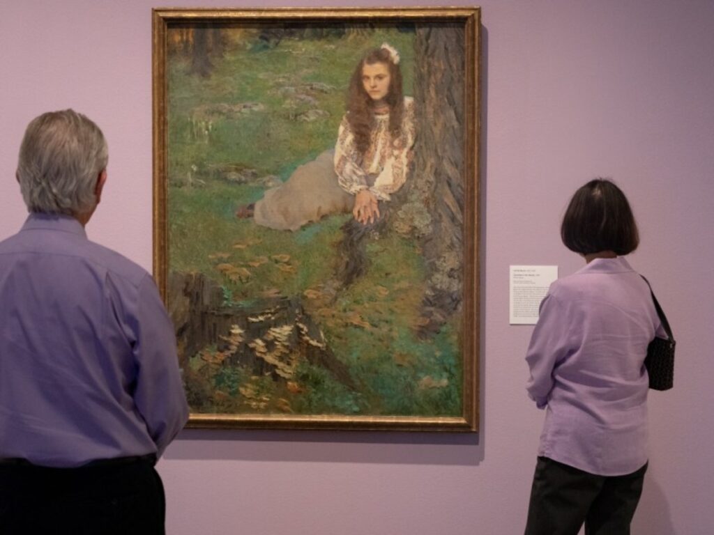 A painting being observed by two spectators