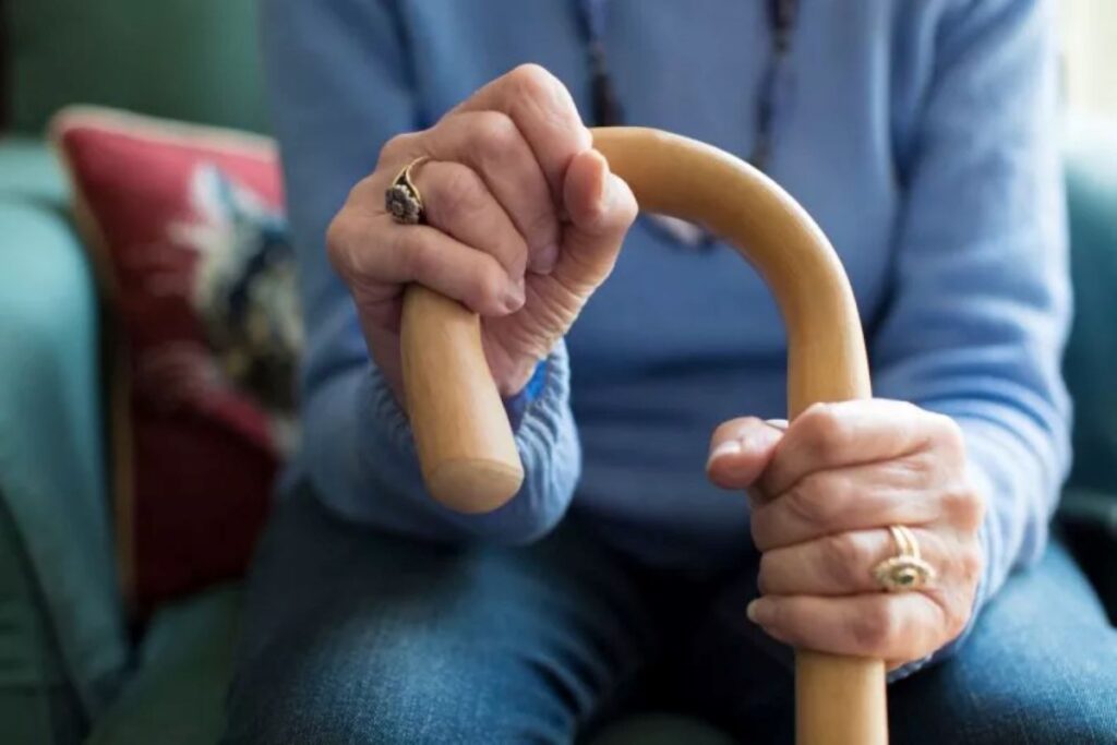 Aged woman holding a walking stick