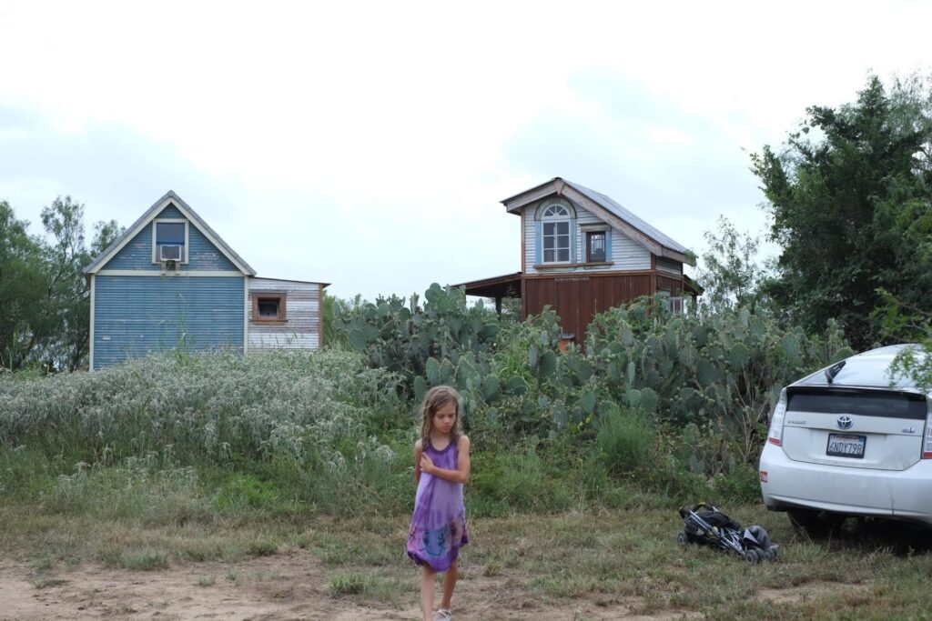 Inés, in front of 2 of the tiny houses