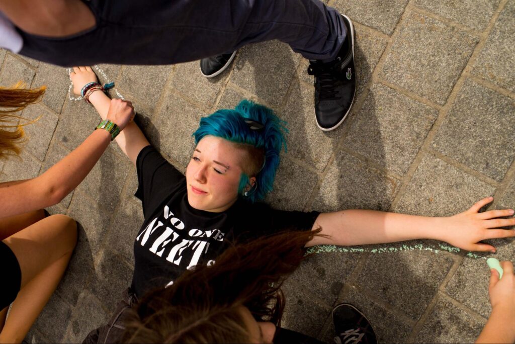 Young adult with dyed hair lying on the floor