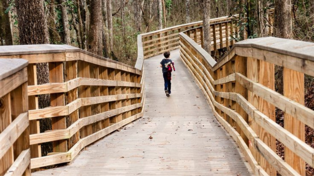 A kid running through a wooden bridge in Alabama