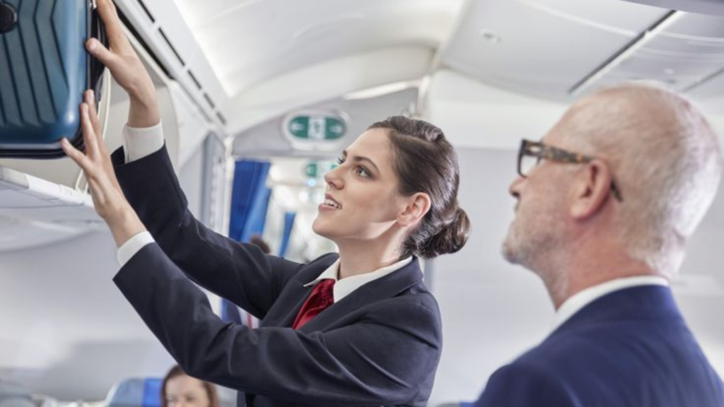 Flight attendant storing luggage in an aircraft