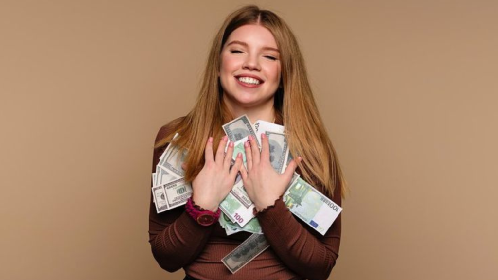 A girl holding bundles of cash