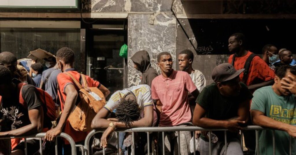 Migrants in a long queue waiting to get accommodation