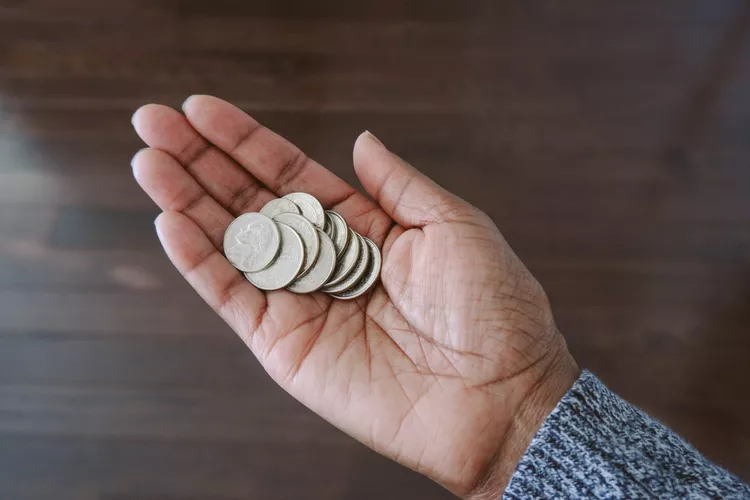 A hand holding some coins