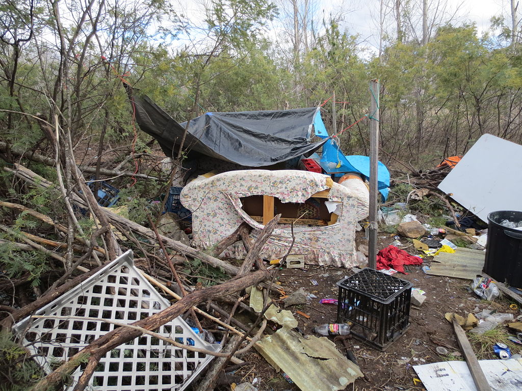 Makeshift homeless shelter abandoned plastic tarp for rain protection