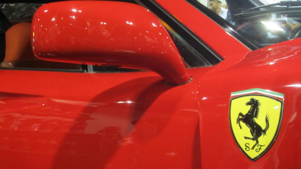 A yellow Ferrari badge on a red Ferrari F40