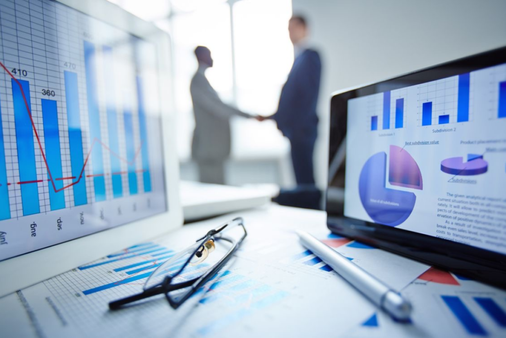 An image of a financial advisor table and two people shaking hands in the background