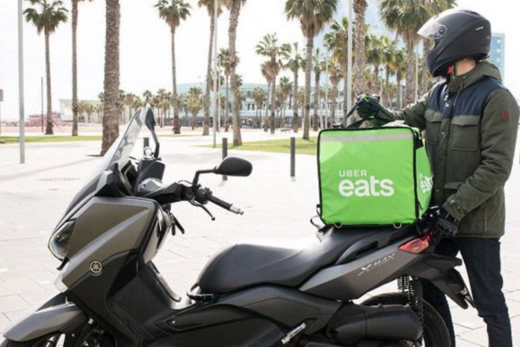 An image of an Uber Eats driver holding an Uber Eats bag