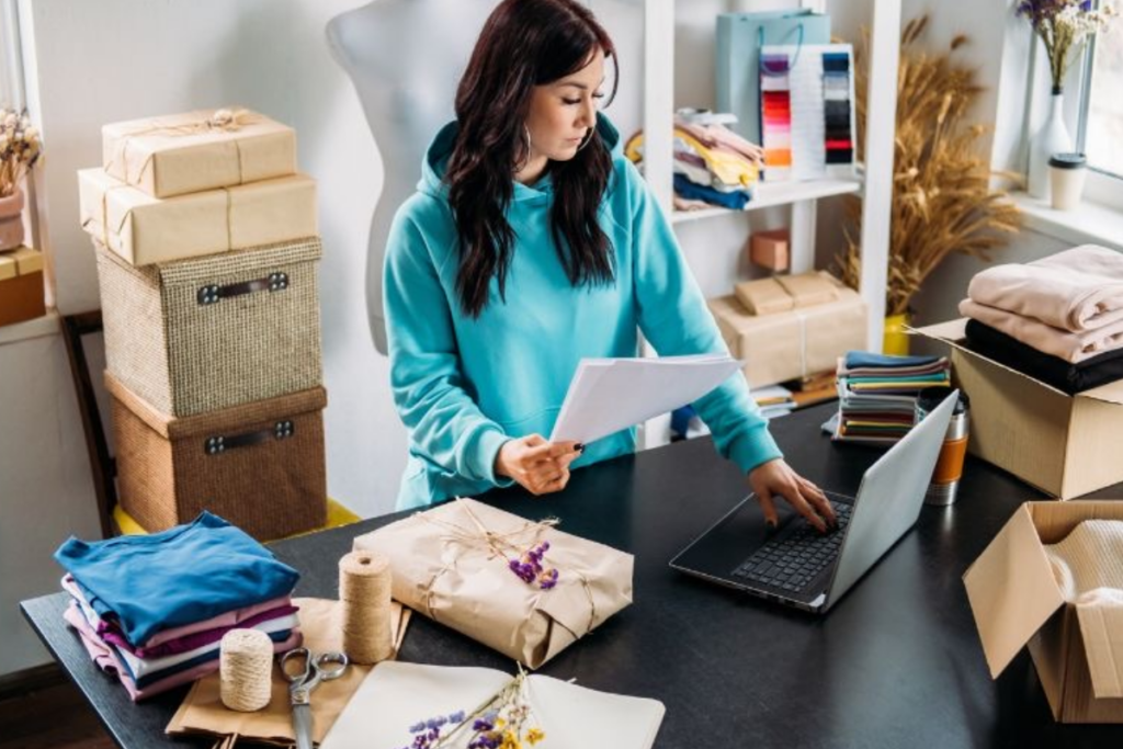 An image of a woman working on a with parcels around her