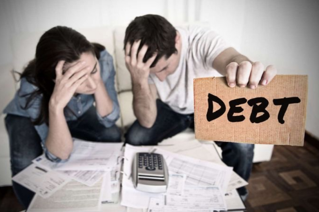 An image of two people with one person holding a paper with debt written on it