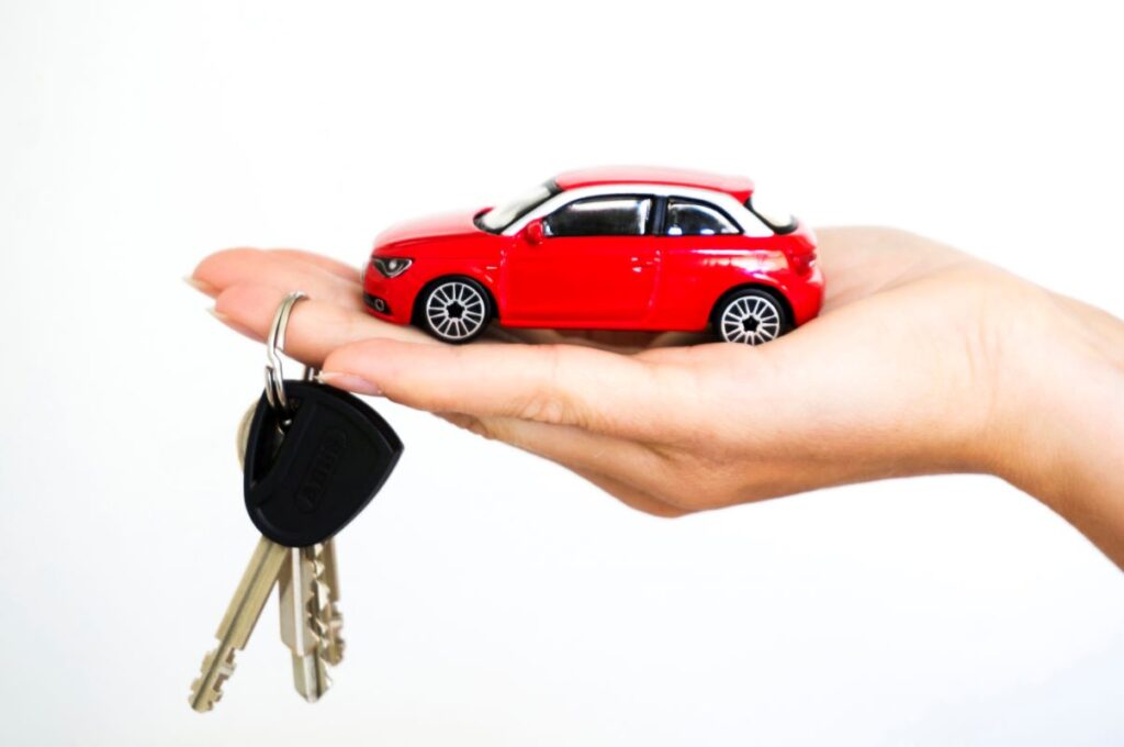 Red model car and keys in hand