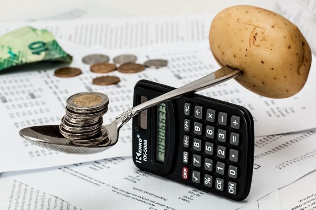 Balancing out some money and a potato on top of a calculator