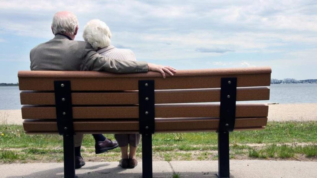 A senior couple sitting on a public bench