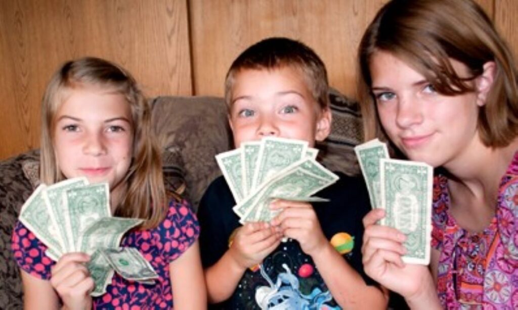 Three kids displaying their pocket money