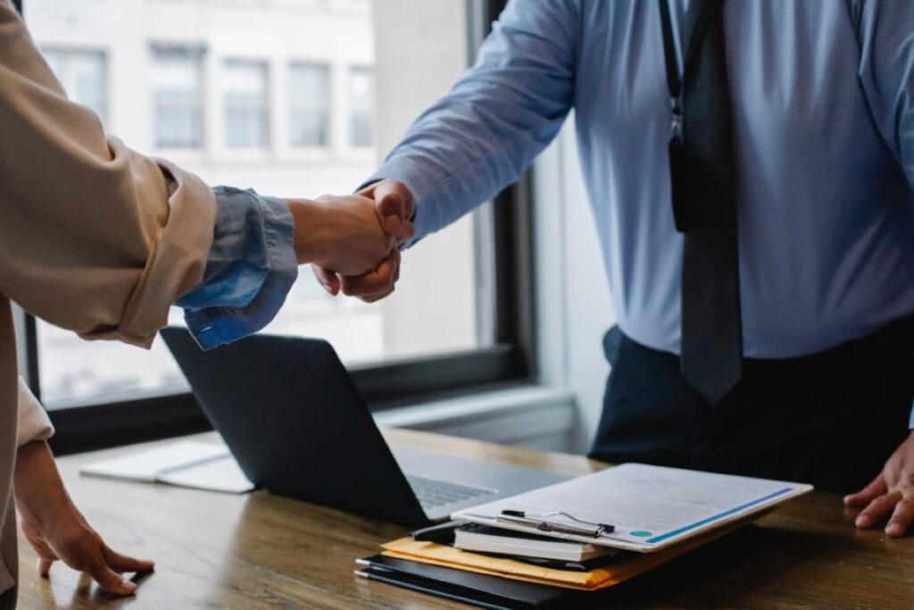 Two people shaking hands to close a deal