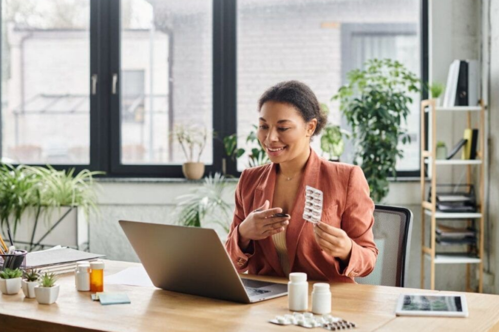 An image of a nurse holding medication and talking to him patient on her laptop