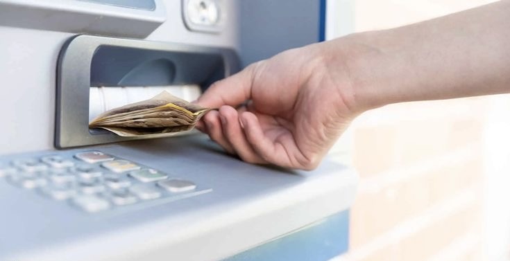 An image of a person withdrawing money from an ATM