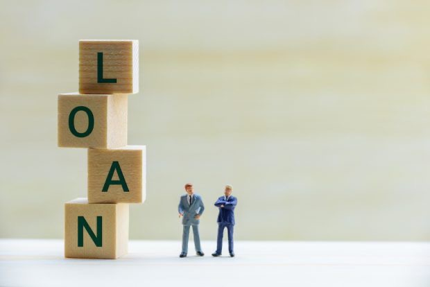 An image of two small figures beside stacked blocks, but spells the word loan