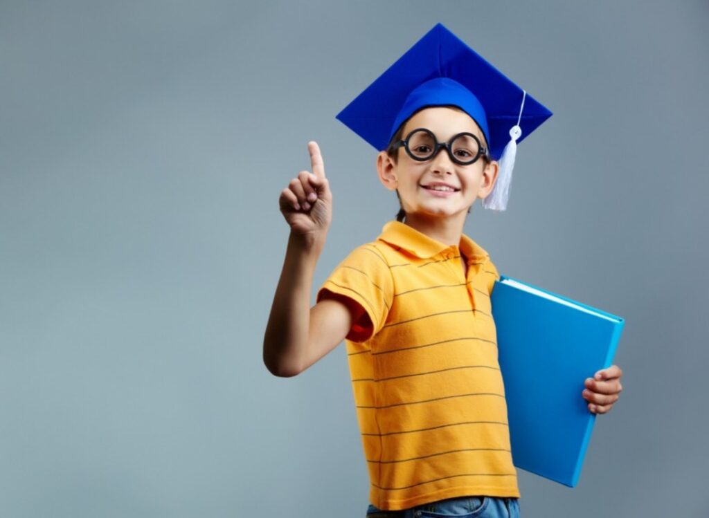 A young boy wearing a graduation cap