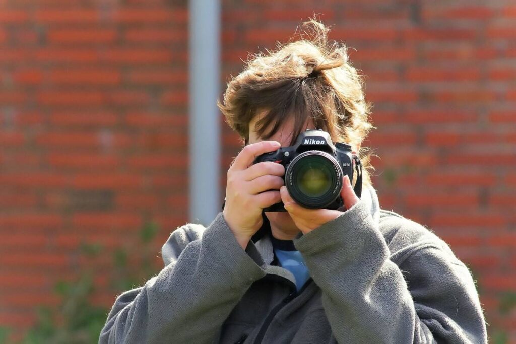 A female photographer taking a shot with a Nikon camera