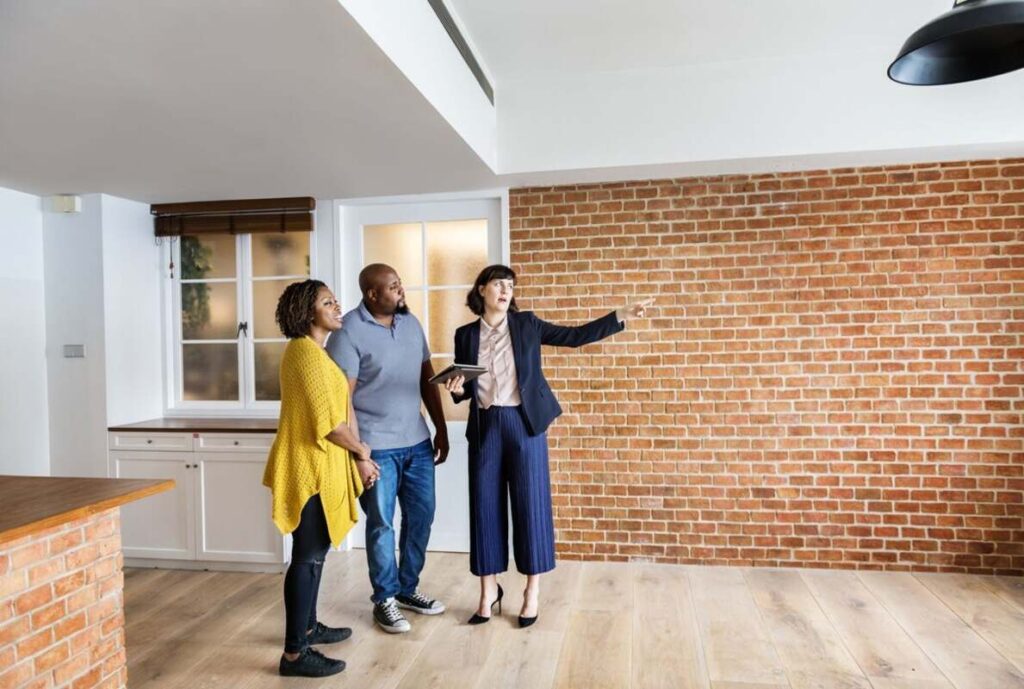 A real estate agent showing a couple around an unoccupied apartment