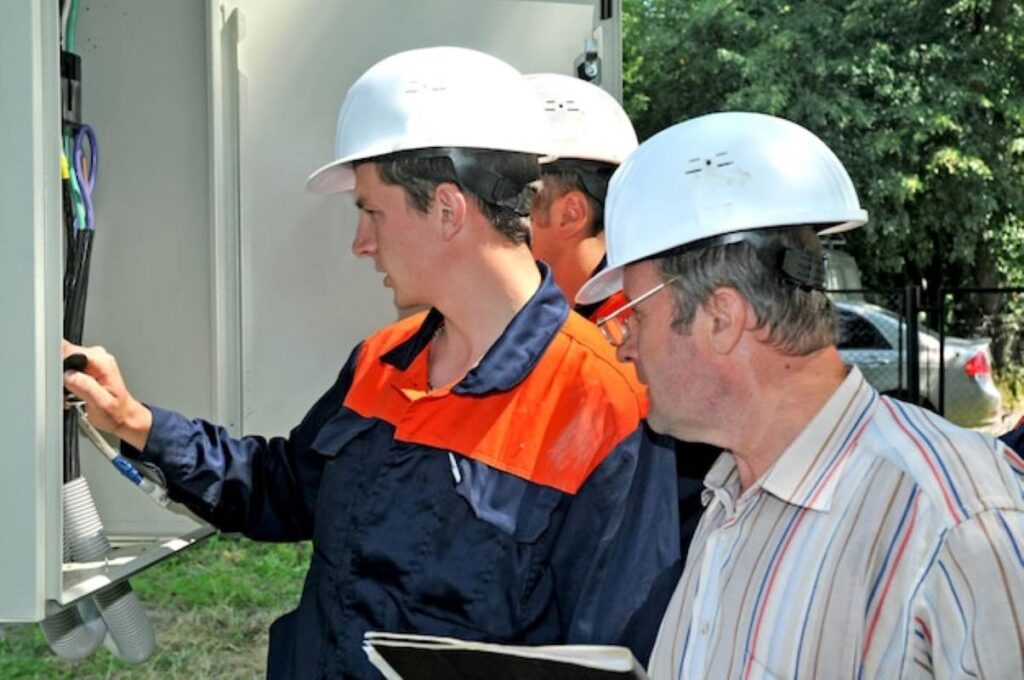 Electrical engineers assessing a power installation