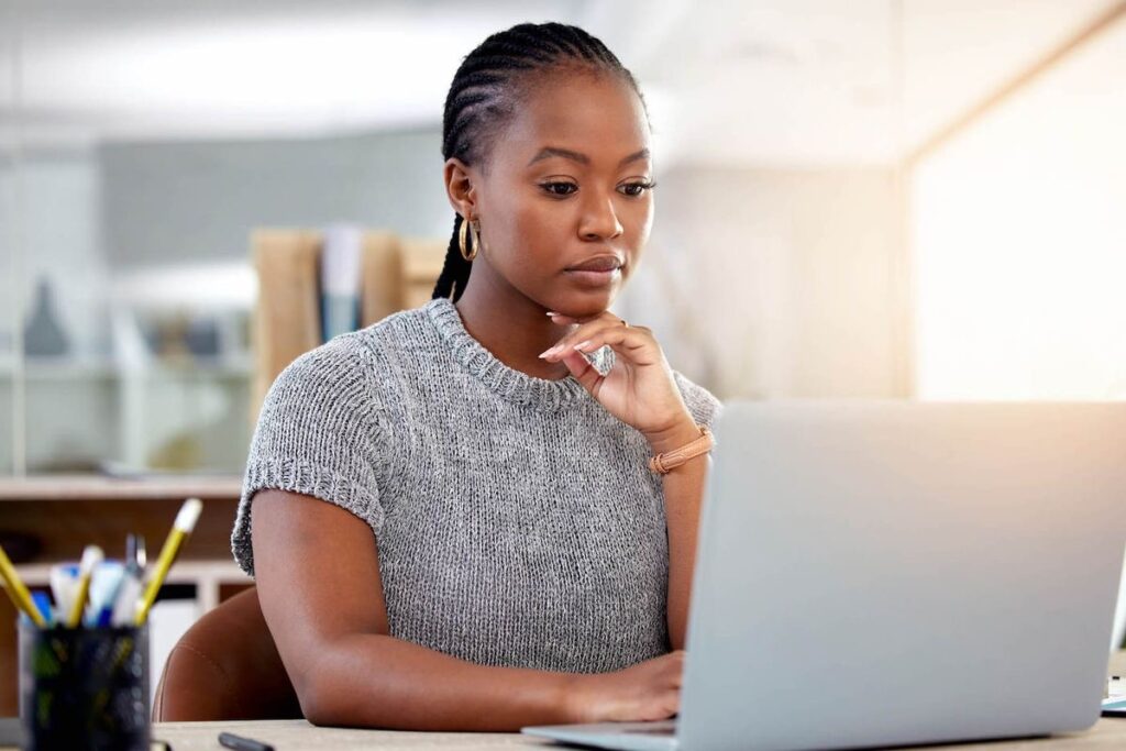 An image of a woman working on a laptop