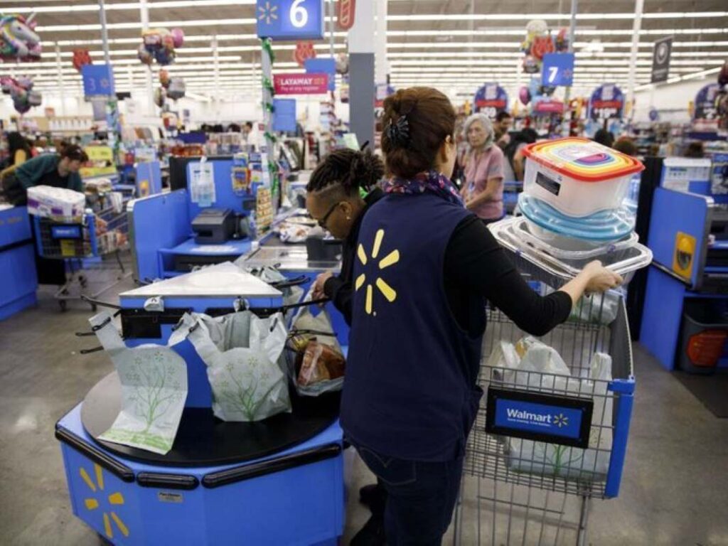 A Walmart employee assisting shoppers in moving items around