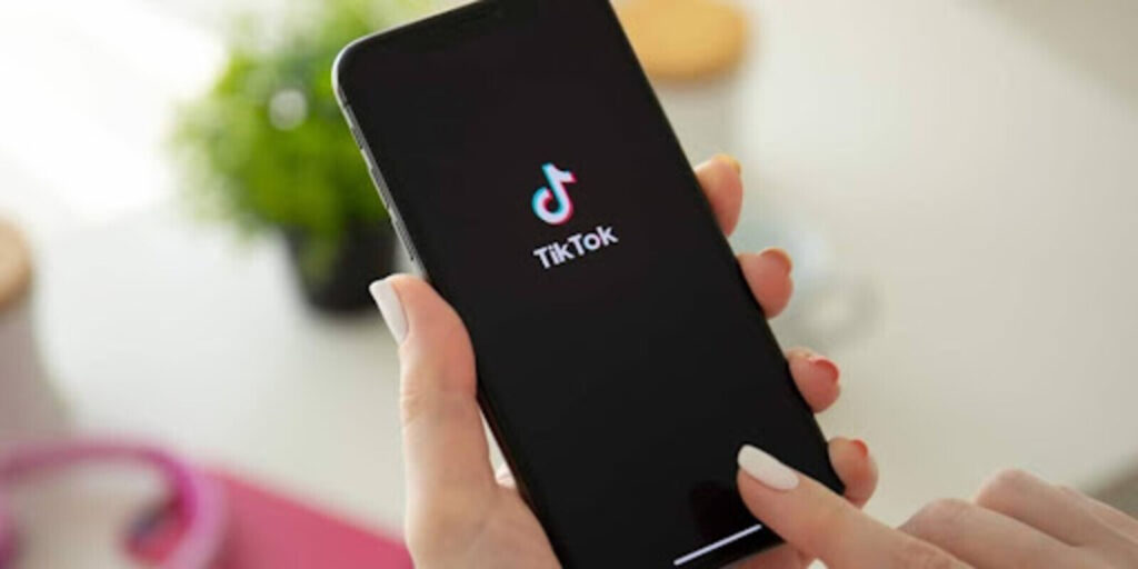 Someone holding a smartphone with the TikTok logo