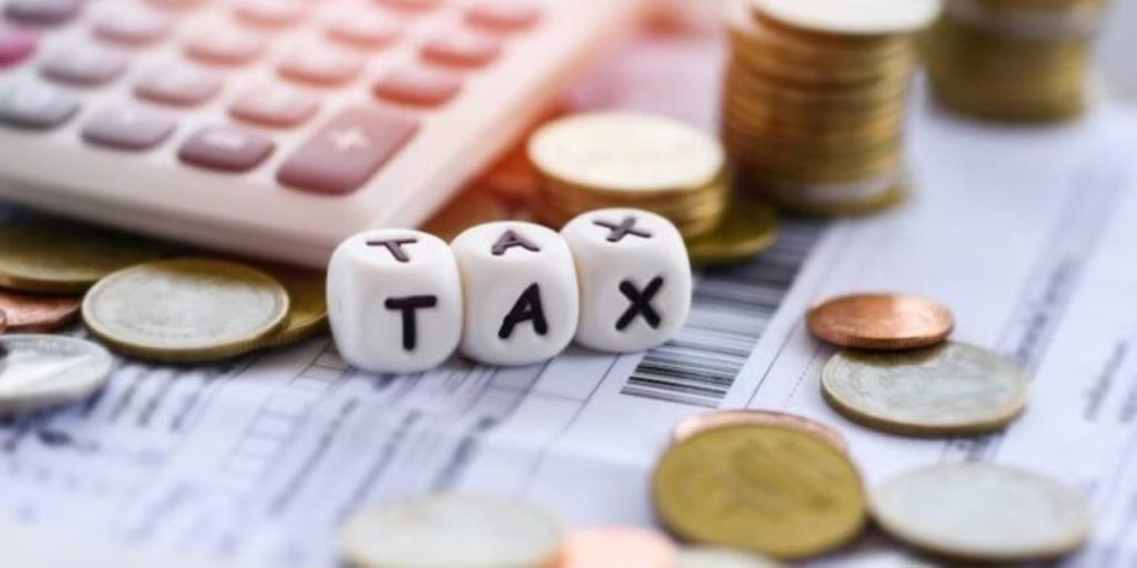 Dice with tax inscribed on, coins and a calculator